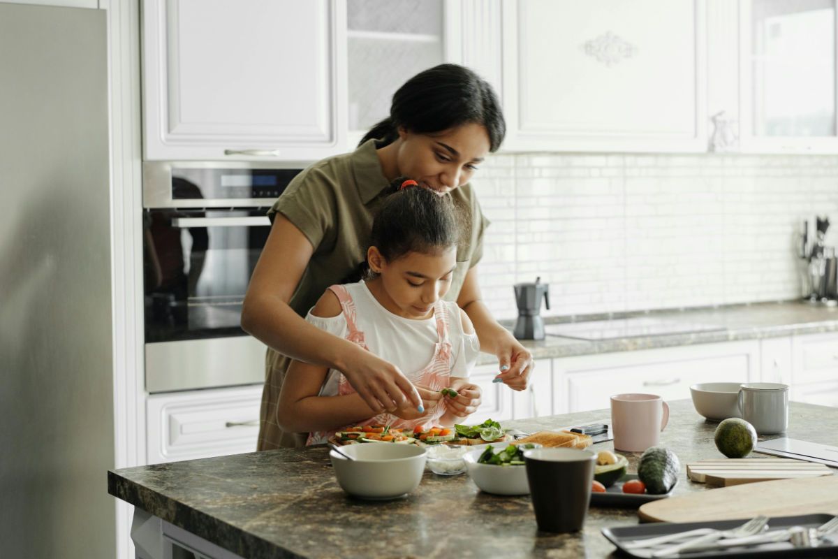 Mom and daughter cooking together in their new home.