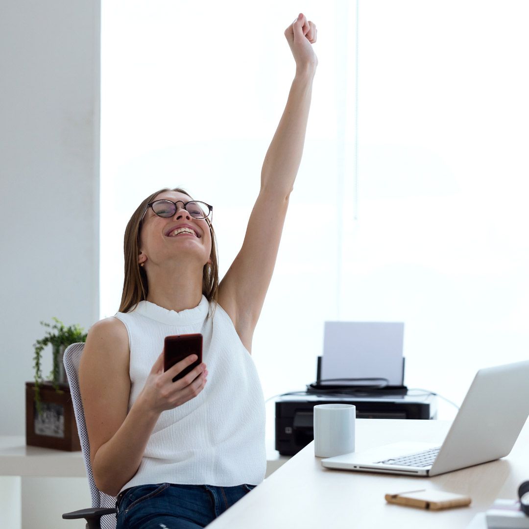 Person cheering at their desk.