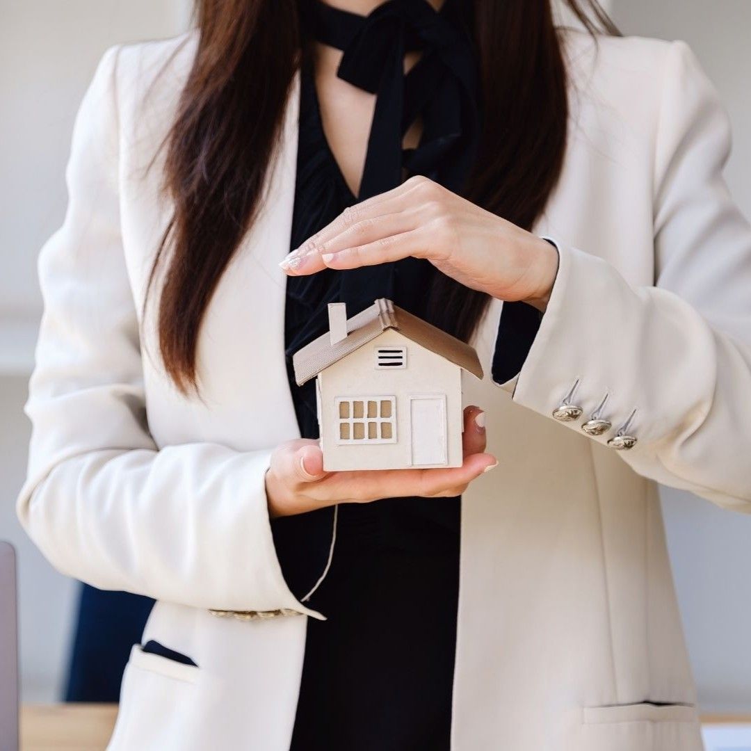 Property management in Oakland and Somerville shown by a professional holding a model rental home