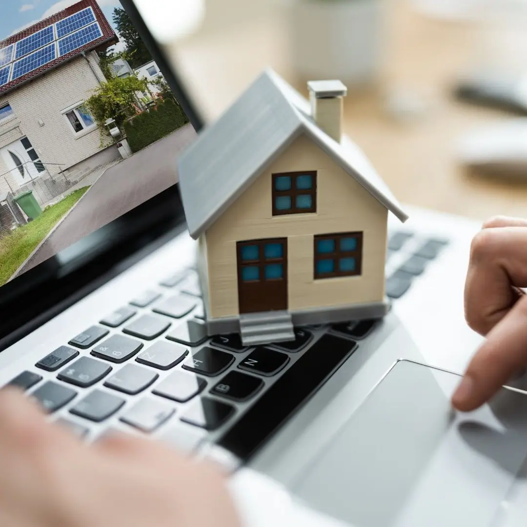 Model house sitting on a laptop keyboard while someone types, symbolizing digital tools used for Southaven property management services.