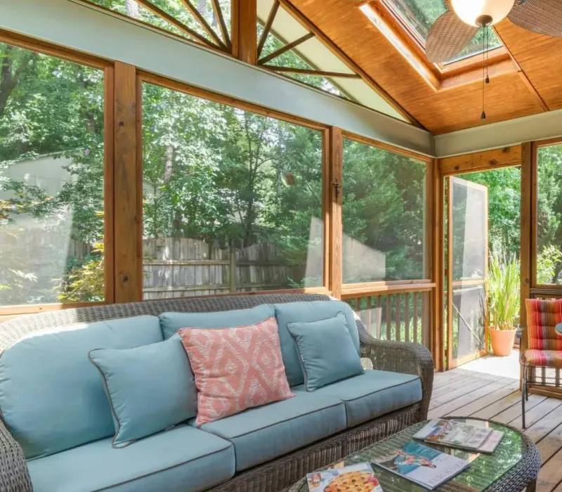 Screened sunroom with wood ceiling, skylight, ceiling fan, and seating area for a renovated rental property in Piperton, TN