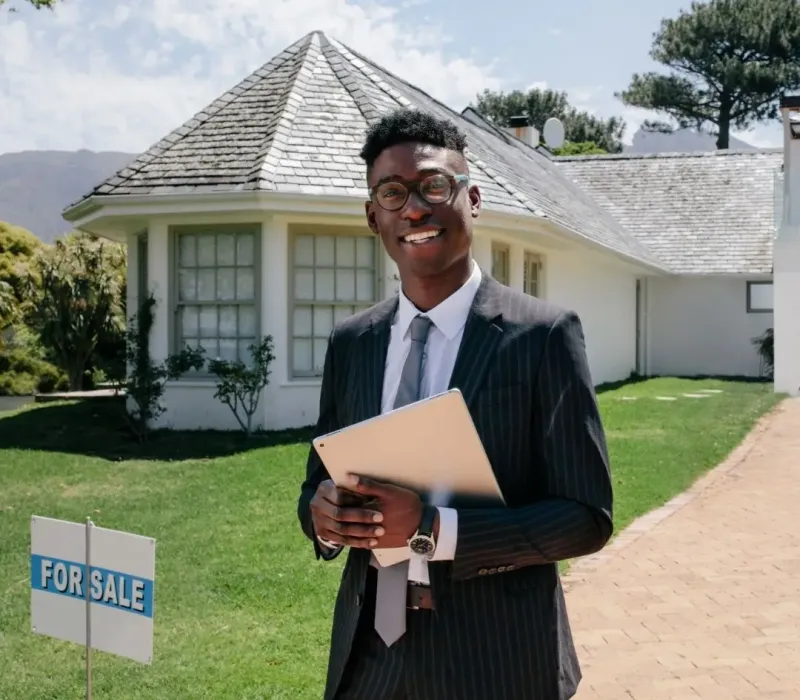 Real estate agent standing in front of a for sale investment property in Millington, TN representing BRRRR acquisition opportunities