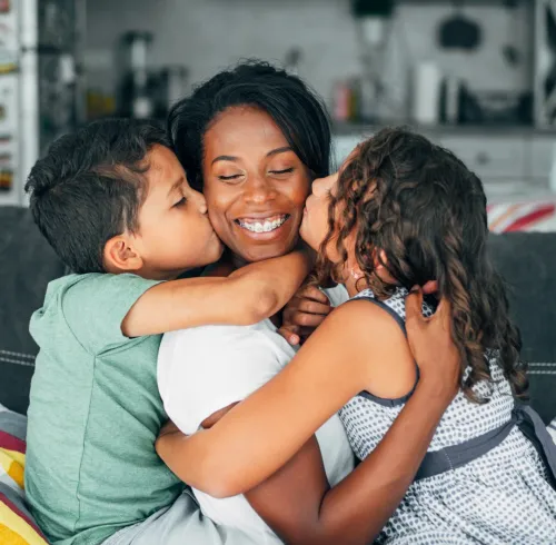 Family hugging on a couch.