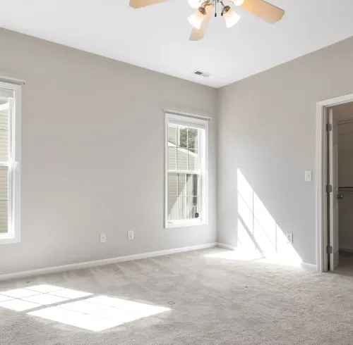 Clean, empty rental unit bedroom with new carpet and a ceiling fan, ready for a Section 8 tenant in Memphis, TN