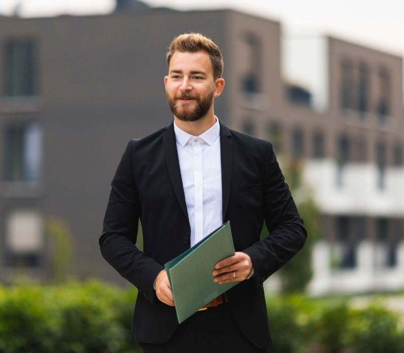 Real estate agent in Lakeland, TN holding documents representing agent partnership for BRRRR investment property transactions with Advantage Property Management