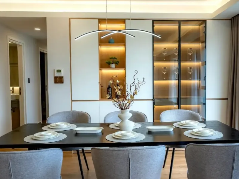 Modern dining room renovation with recessed lighting, built-in shelving, and a long table in Piperton, TN